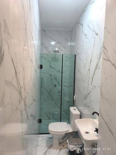 a bathroom with a toilet and a shower and a sink at Apto Lindo e Aconchegante 3 in Manaus