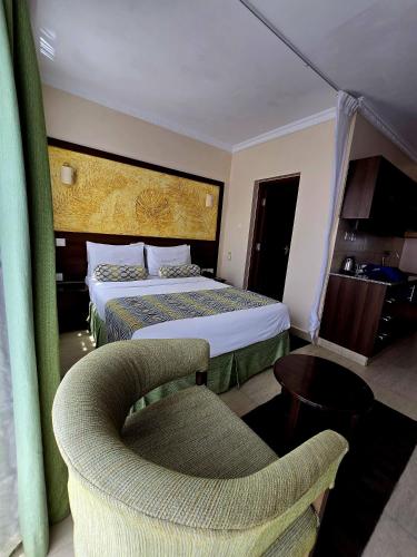 a hotel room with a bed and a chair at Vittoria Suites Milimani, Kisumu in Kisumu