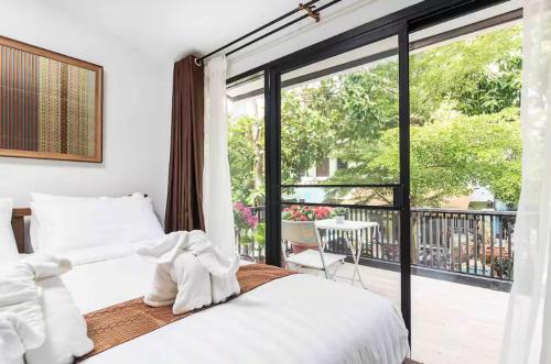a bedroom with a bed and a large window at Baan Ploen Dee - Wat Arun in Bangkok
