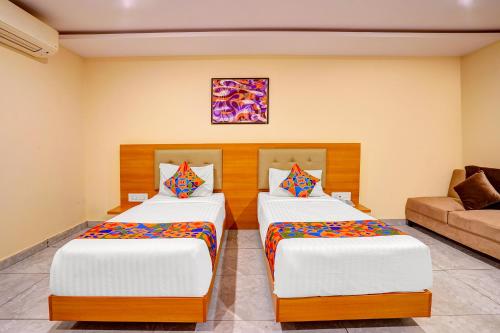 a bedroom with two beds and a couch at FabHotel Millennials in Bengaluru