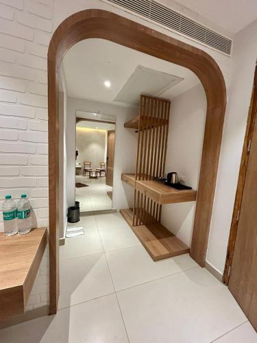 a hallway with an archway in a house with a kitchen at Three Oceans Resort in Kanyakumari