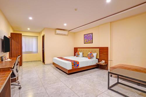 a hotel room with a bed and a television at FabHotel Millennials in Bengaluru