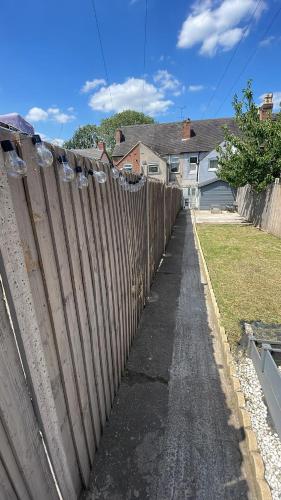 a wooden fence in front of a house at Waterside Stay- 3 Bed House- Sleeps 5- Parking- Fast Wifi in Burton upon Trent