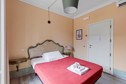 a bedroom with a bed with a red blanket at Ostello Bello Firenze in Florence