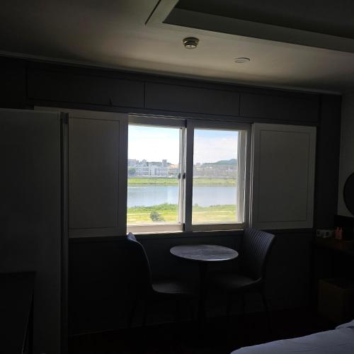 a room with a window with a table and a view at Yeoju Hightel in Yeoju