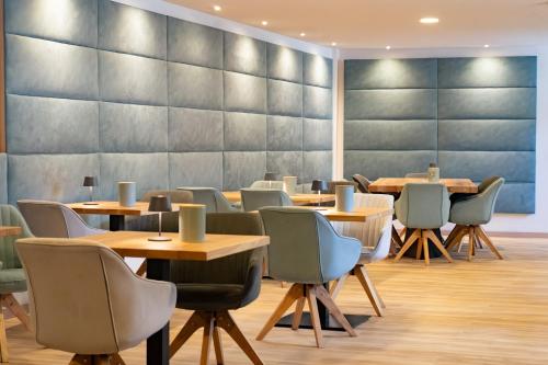 Un comedor con mesas y sillas de madera. en KRACHER Familienapartment mit Nationalparkblick, en Illmitz