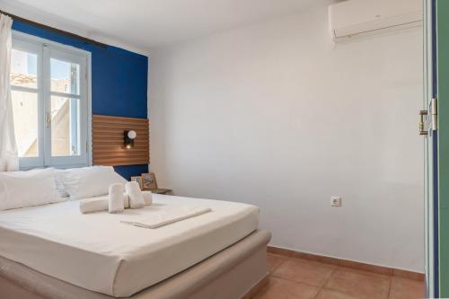 a white bed in a room with a window at La Casa Tinos 22 in Agios Ioannis Tinos