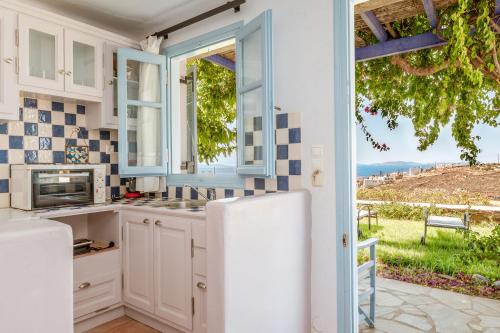 a kitchen with a white refrigerator and a window at La Casa Tinos 22 in Agios Ioannis Tinos