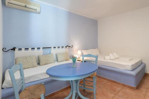 a small room with a blue table and a bed at La Casa Tinos 22 in Agios Ioannis Tinos