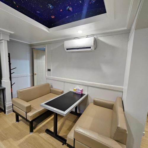 a living room with a table and chairs and a star ceiling at Yeoju Hightel in Yeoju