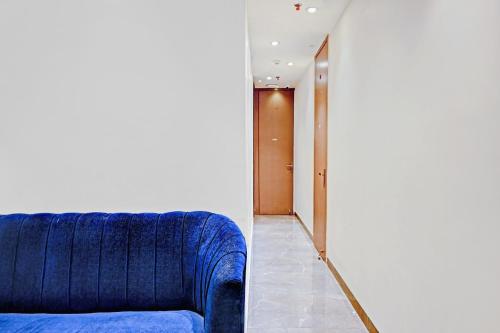 a blue couch in a room with a hallway at Hotel O Vrindavan in Kolkata