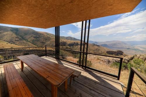 a wooden bench on a deck with a view of mountains at Sareni in Areni