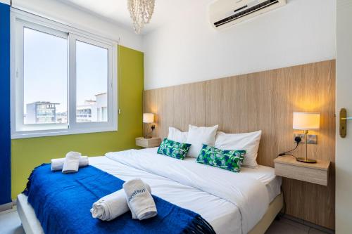 1 dormitorio con 2 camas y paredes azules y verdes en Whispering Palms 1-BR Apt By Finikoudes Beach, en Lárnaca