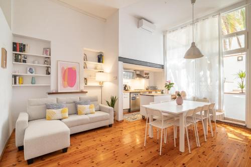 a living room with a white couch and a table at ARTSY Apartment 3BTH and 6BR FIRA Montjuic Plaza España FCB in Barcelona