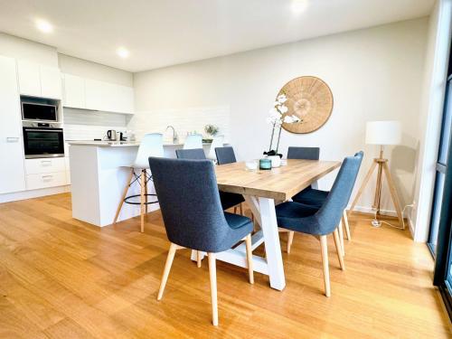 Una cocina y un comedor con mesa y sillas de madera. en Spacious 4BR w/ Water Views, en Port Macquarie