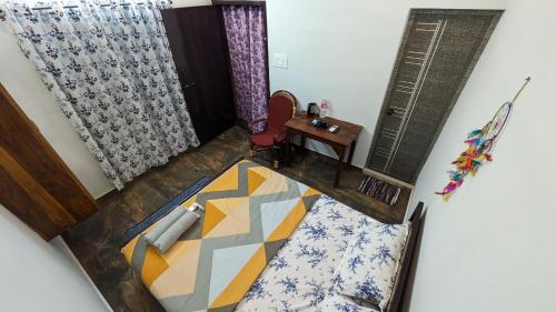 a bedroom with a bed and a table and a window at HostelExp, Varkala - A Beach Town Hostel in Varkala