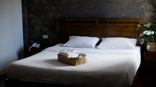 a basket of towels sitting on a bed at Delio Boutique Hotel in Udon Thani