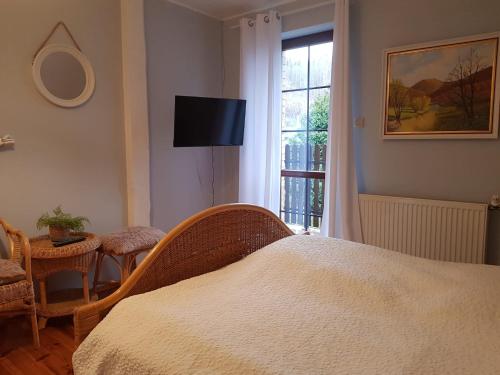 ein Schlafzimmer mit einem Bett und einem Tisch und einem Fenster in der Unterkunft Mikołajówka - przytulny dom z widokiem in Świeradów-Zdrój