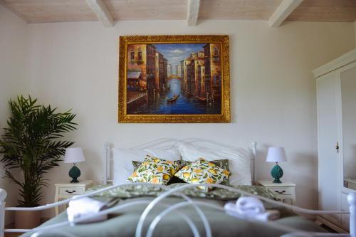 a painting hanging on a wall above a bed at Anna Vendégház Kesztölc in Kesztölc