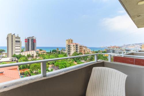 a chair on a balcony with a view of the city at Al Murjan Palace Hotel Jounieh in Jounieh