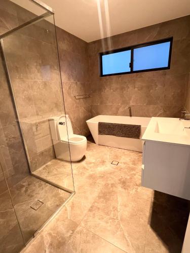a bathroom with a shower and a toilet and a sink at Spacious Queen Room with Attached Bathroom - OR1 in Guildford