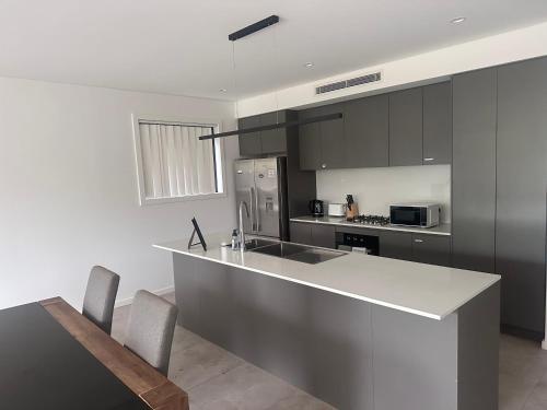 a kitchen with a counter and a sink and a stove at Spacious Queen Room with Attached Bathroom - OR1 in Guildford