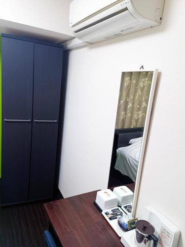 a bedroom with a mirror and a desk with a bed at Ace Inn Asakusa in Tokyo
