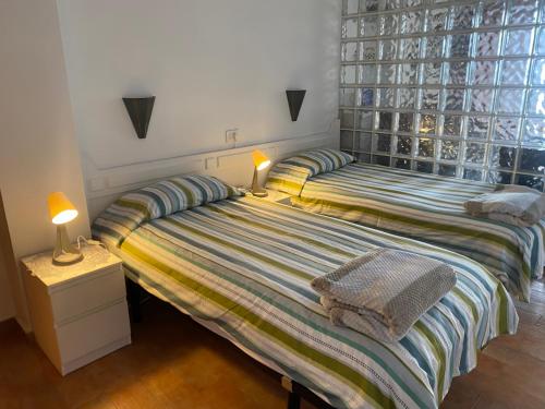 a bedroom with two beds and two lamps on a night stand at Estudio luminoso, primera línea de playa de las canteras in Las Palmas de Gran Canaria