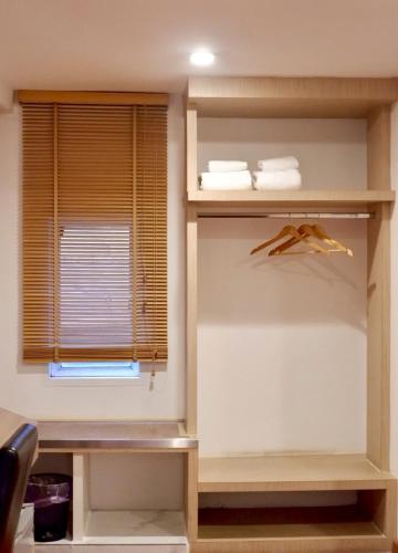 a room with a window and a shelf with towels at Delio Boutique Hotel in Udon Thani