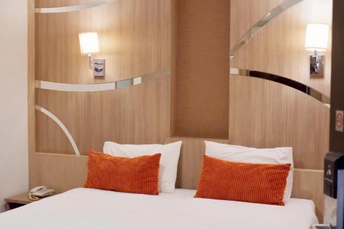 a bedroom with a bed with orange and white pillows at Delio Boutique Hotel in Udon Thani