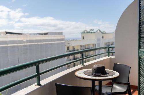un sombrero sentado en una mesa en un balcón en Golden Star AU by An Island Apart, en Funchal