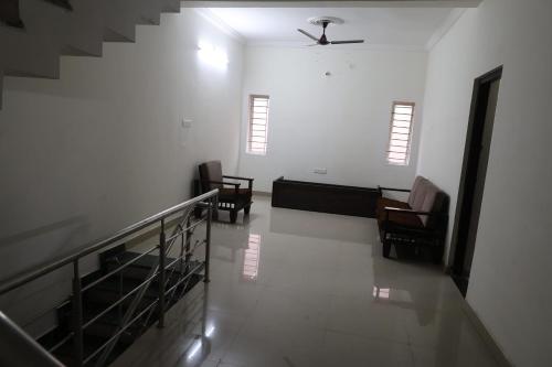 a hallway with two chairs and a ceiling fan at Villas by Caesars Palace in Bhopal