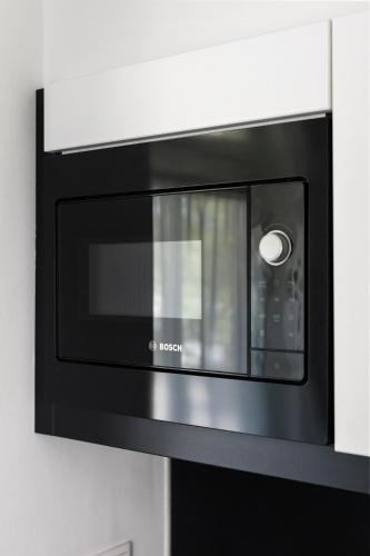 a black microwave oven hanging on a wall at B's Strandappartementen in Domburg