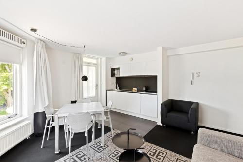 a kitchen and living room with a table and chairs at B's Strandappartementen in Domburg