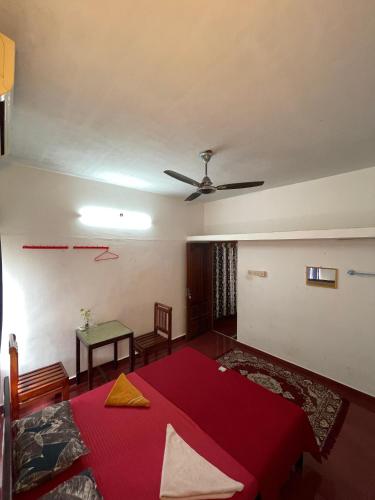 a bedroom with a red bed and a ceiling at HostelExp, Varkala - A Beach Town Hostel in Varkala