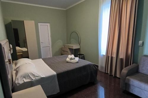 a bedroom with a bed and a chair and a mirror at 4 Bed Villa-Sleeps 8-Parking-Garden-Sea View in Ureki