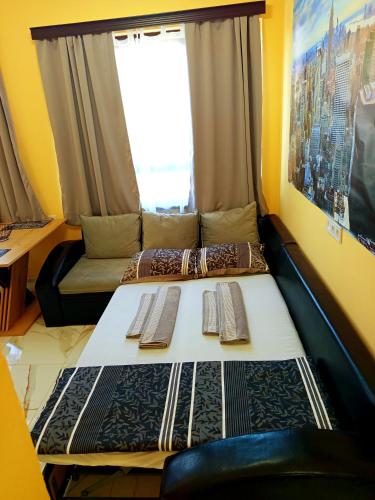 a bed in a room with a couch and a window at Elixir2 Apartment Еликсир2 in Shumen