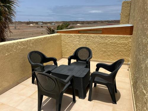 a patio with four chairs and a table on a balcony at P&SRelax in Palha Verde