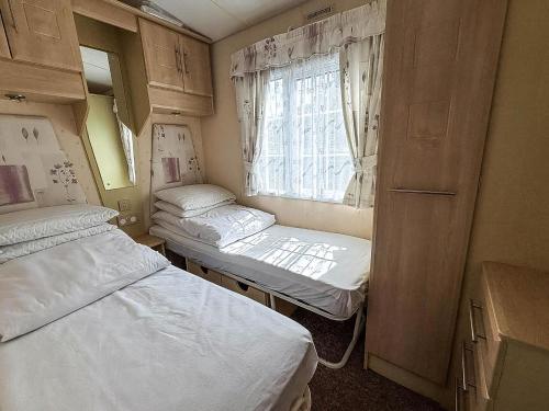 a small room with two beds and a window at Great 6 Berth Caravan For Hire At Cherry Tree Holiday Park In Norfolk Ref 70801C in Great Yarmouth