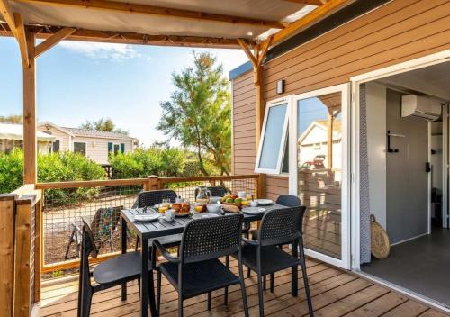 a patio with a table and chairs on a deck at Camping Marvilla Parks Kaatsheuvel in Kaatsheuvel