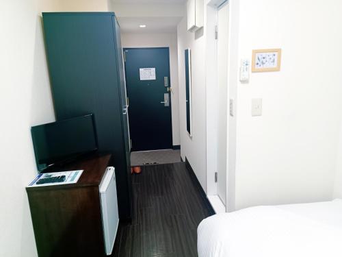 a room with a hallway with a door and a television at Ace Inn Asakusa in Tokyo