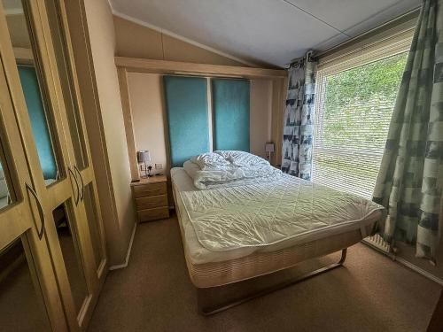 グレート・ヤーマスにあるBeautiful 6 Berth Lodge At Cherry Tree Holiday Park Ref 70002Tgのベッドと窓のある小さな寝室