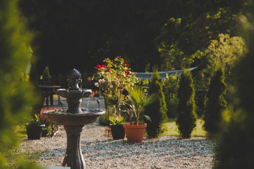 a fountain in a garden with potted plants at Wohnung Wilhelm in Behren-Lübchin
