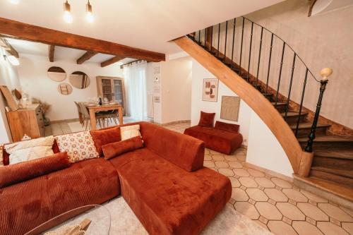 a living room with a brown couch and a staircase at The Champenoise Jacuzzi - Vineyard in Verzenay