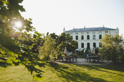a building with tables and umbrellas in a park at Wohnung Wilhelm in Behren-Lübchin