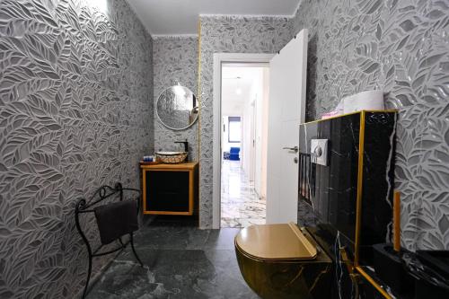 baño con aseo en una habitación con papel pintado en נופש תות - דירת אירוח בלב טבריה עם ג'קוזי ספא, en Tiberíades