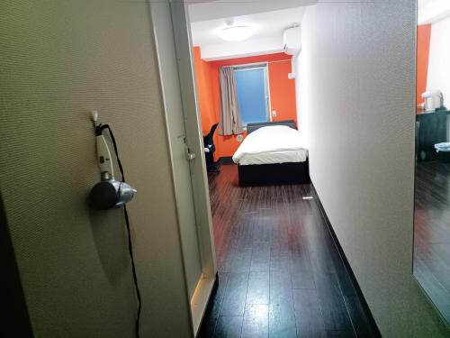 a room with a bedroom with a bed and a door at Ace Inn Asakusa in Tokyo
