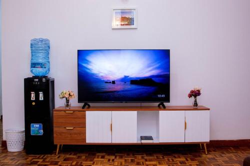 a flat screen tv sitting on top of a entertainment center at KAREN Comfort 3BR Holiday Home Nandi Rd off Miotoni in Nairobi