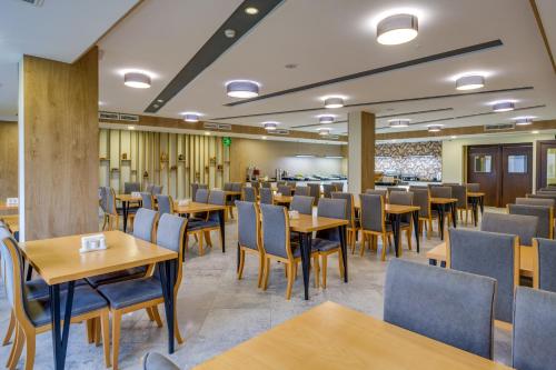 a dining room with wooden tables and chairs at Hotel Salvador in Batumi