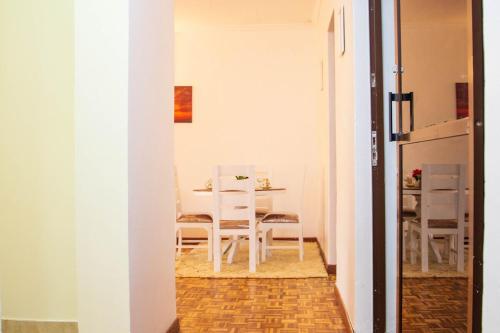 a dining room with a white table and chairs at KAREN Comfort 3BR Holiday Home Nandi Rd off Miotoni in Nairobi